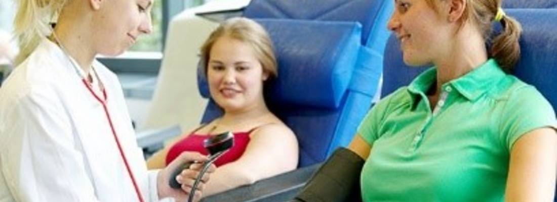 Ärztin misst vorbereitend Blutdruck bei einer Patientin