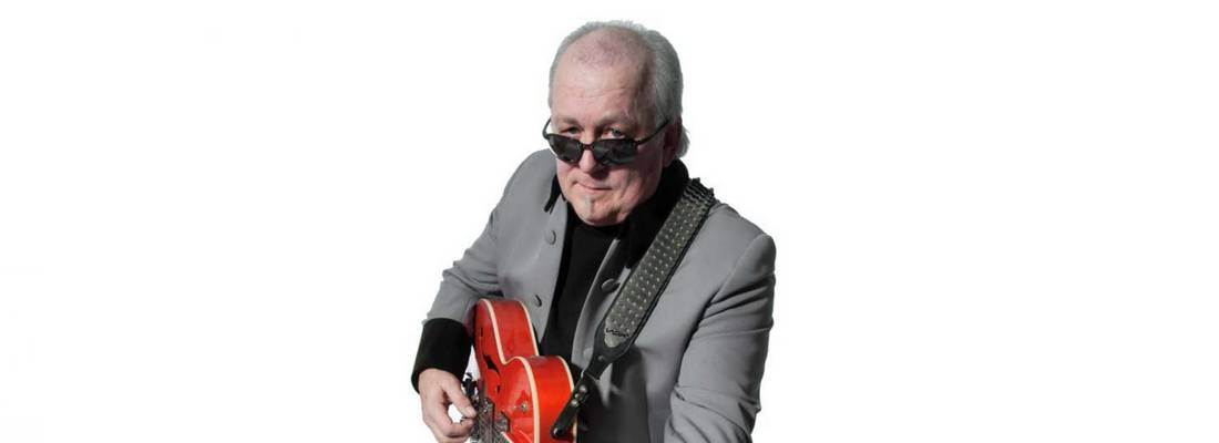 Ein Mann mit Sonnenbrille spielt auf einer Gitarre.