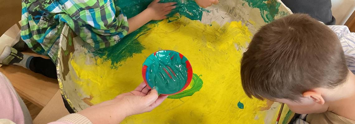 Kinder spielen an einer runden Platte.