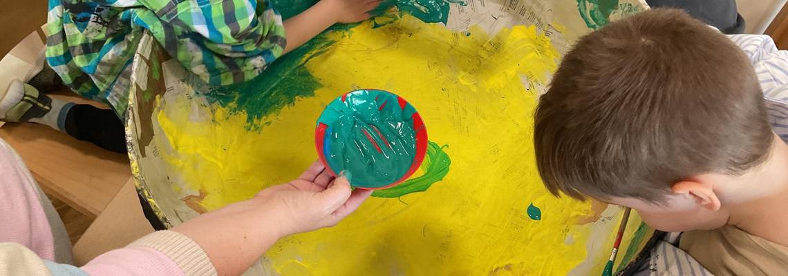 Zwei Jungen sitzen an einem Tisch und haben Flaschen mit Wasser vor sich stehen.