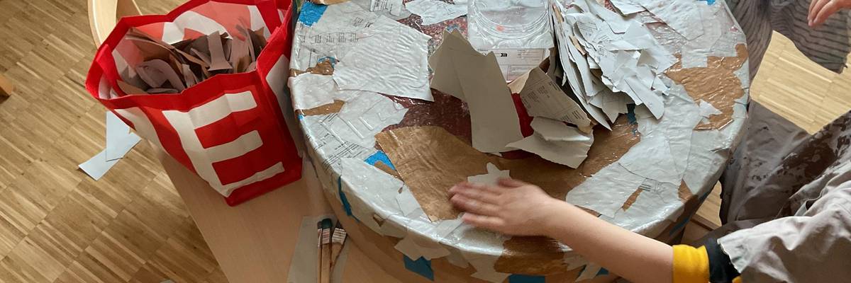 Die Kinder bauen mit Pappe, Zeitungspapier, Kleister und Farbe eine Arena für ihre Beyblades