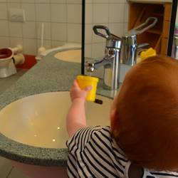 Ein Mädchen steht an einem Waschbecken und wäscht die Hände.