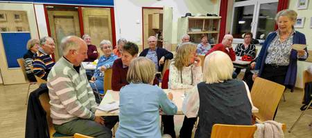 Personengruppe an Tischen, die miteinander sprechen