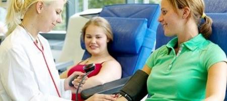 Ärztin misst vorbereitend Blutdruck bei einer Patientin